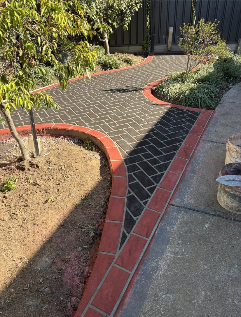 Classic herringbone charcoal concrete with brick coloured edge borders